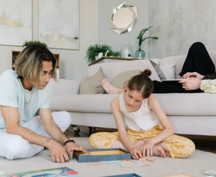 A family enjoying leisure and remote work together in a cozy home setting.